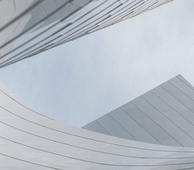 Vista de la parte superior de una estructura arquitectónica moderna con superficies curvadas y rectas.